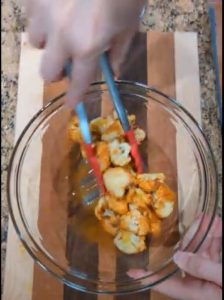 Stir cauliflower florets with buffalo sauce